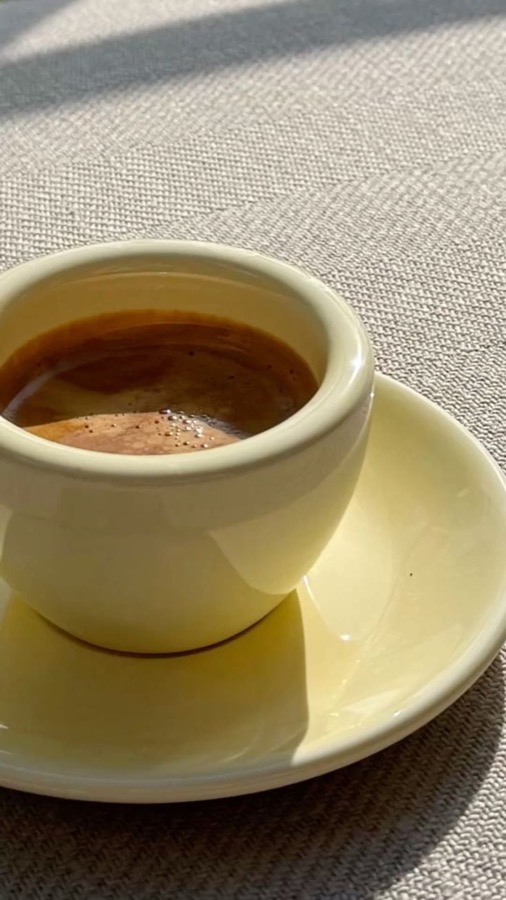 A quiet coffee in a soft yellow cup.